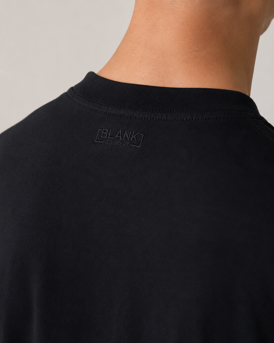 The Standard Fit in Black — Suvin cotton fabric detail on model.